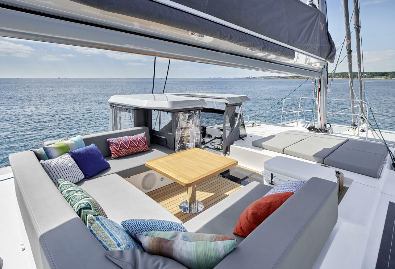 Luxurious yacht deck with cozy seating, colorful pillows, and ocean view, perfect for relaxation and scenic cruising.