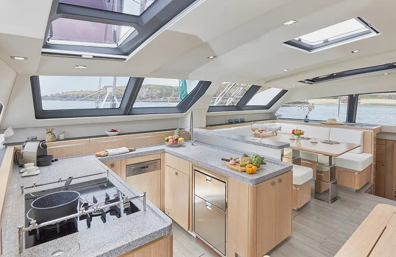 Luxurious yacht kitchen with modern appliances and panoramic windows overlooking serene waters and scenic views.