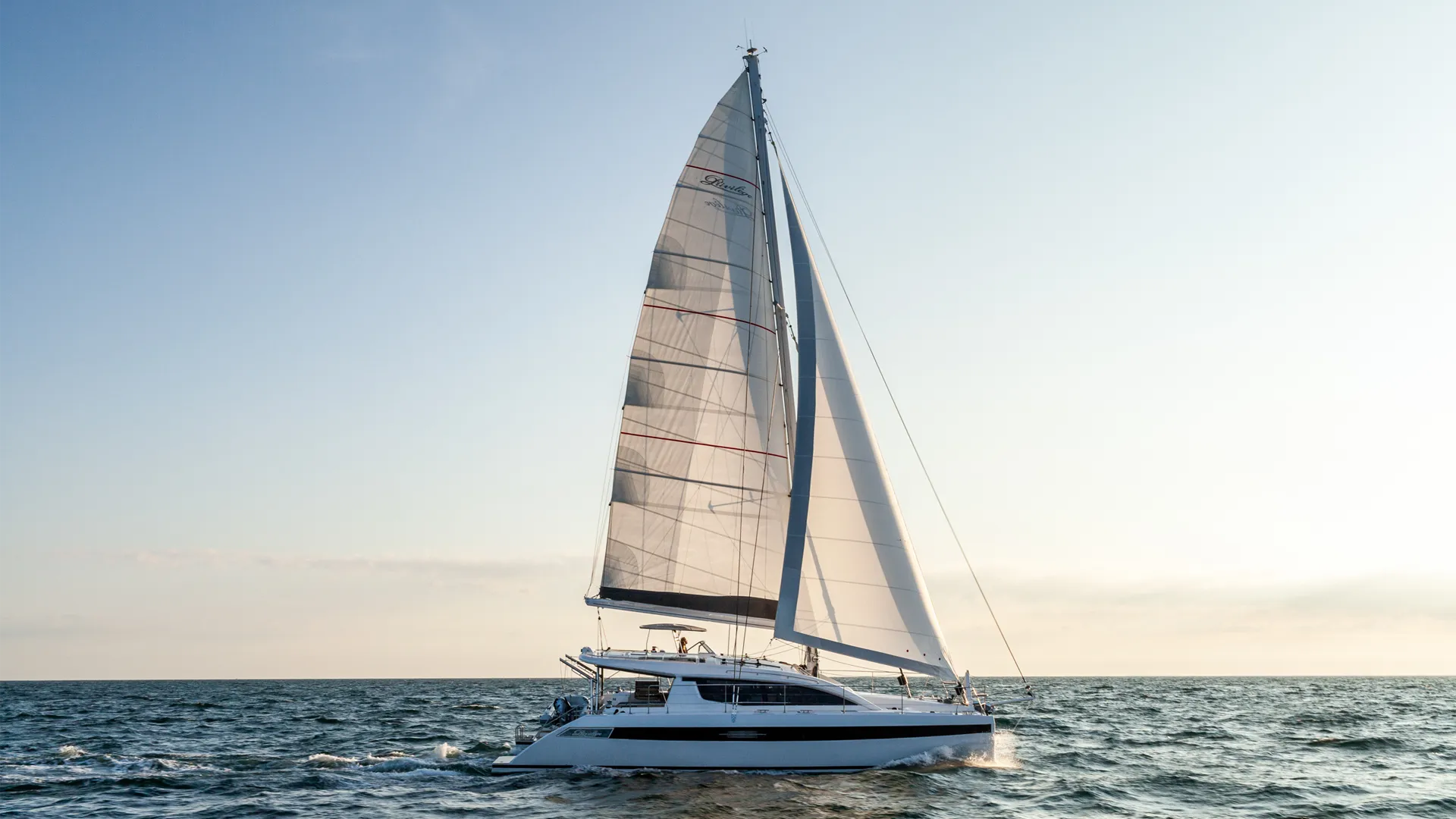 Privilege signature 510 Sailing catamaran navigating open sea under clear skies, capturing adventure and maritime leisure.